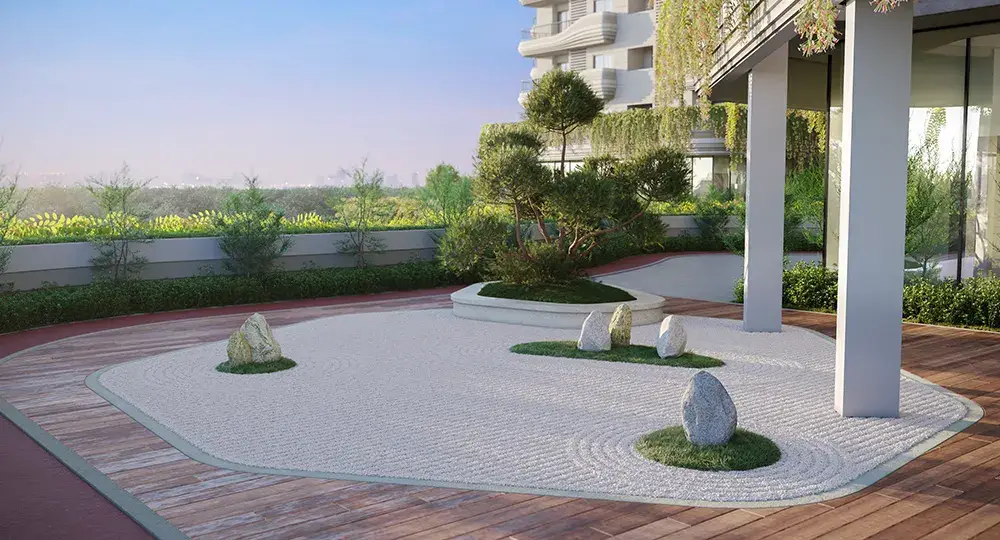 A landscaped garden featuring pebbles, greenery, and decorative rocks under a modern building.