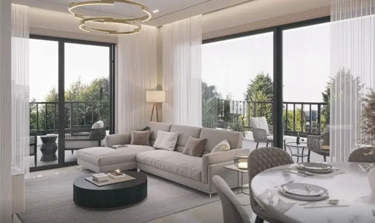Modern living room with a gray sectional sofa, round coffee table, and large windows overlooking greenery.