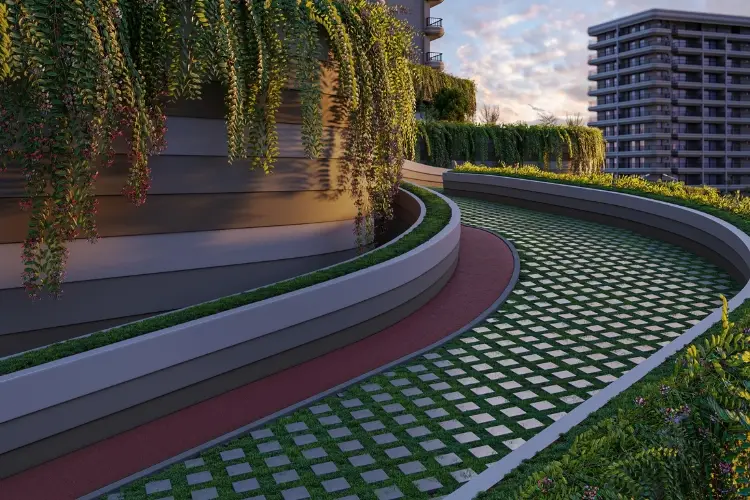 Curved pathway surrounded by greenery and modern buildings, featuring a patterned surface.