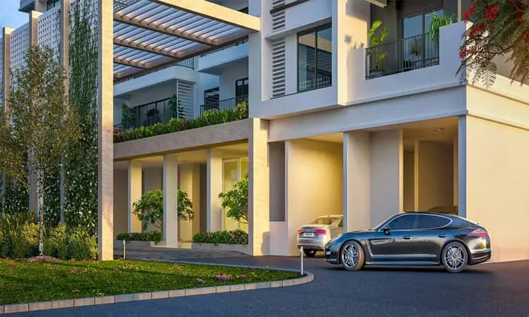 Contemporary building with cars parked, greenery, and large windows in Gurgaon.