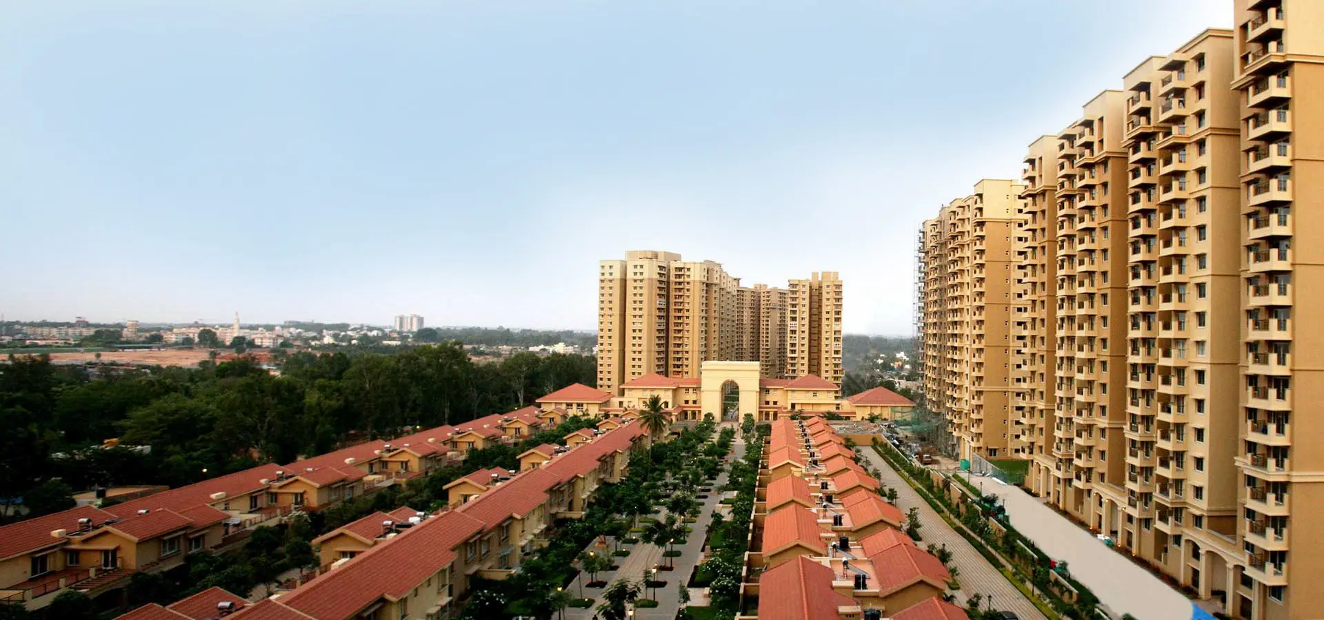 Aerial view of a residential area with multiple buildings and houses, surrounded by greenery.