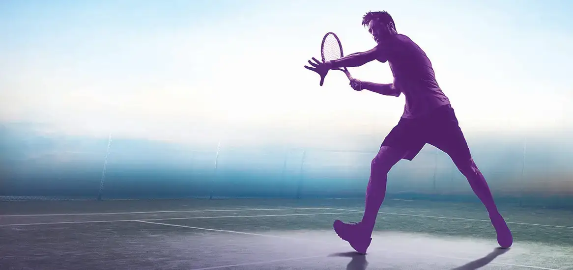 Silhouette of a tennis player preparing to hit a ball on a court.