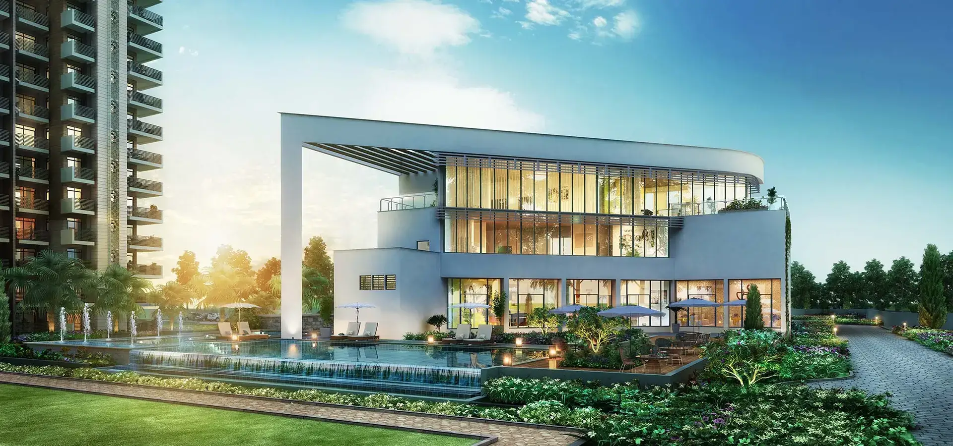 Contemporary building with large glass windows, surrounded by landscaped gardens and a water feature.