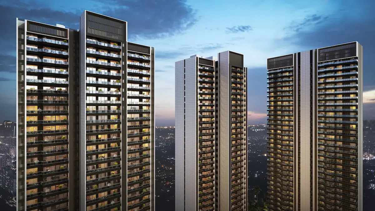 Four modern residential towers with glass facades and balconies under a twilight sky.