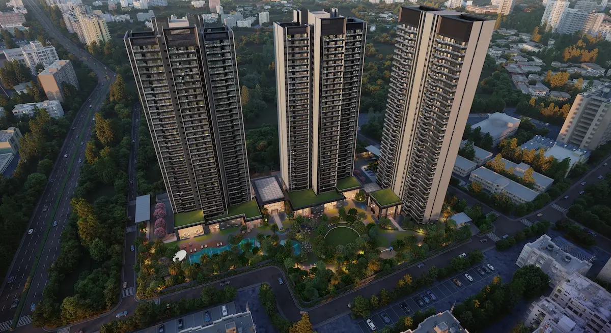 Aerial view of three tall residential towers surrounded by greenery and landscaped gardens.