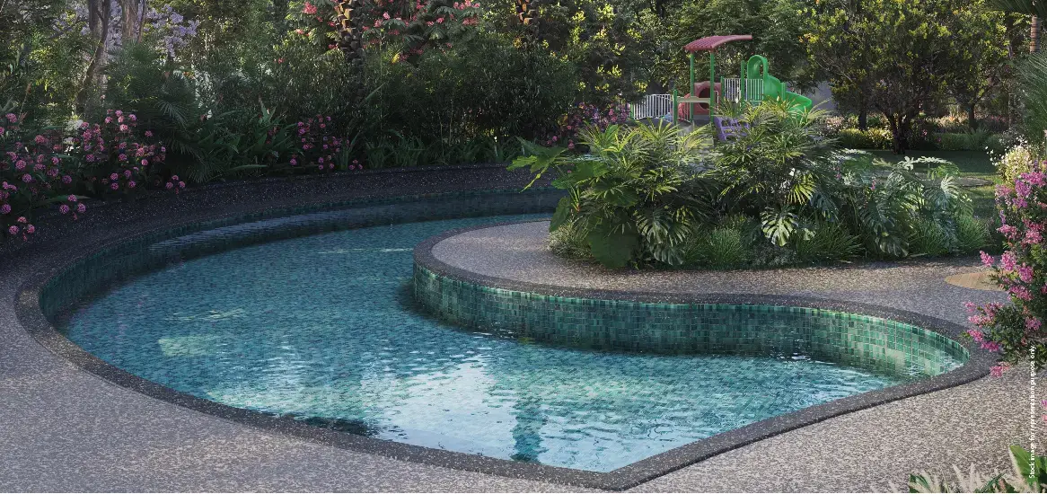 Curved swimming pool surrounded by lush greenery and colorful flowers, with a children's play area.