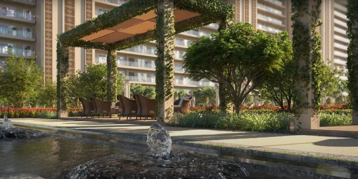 A serene outdoor area with a fountain, seating under a pergola, and lush greenery.