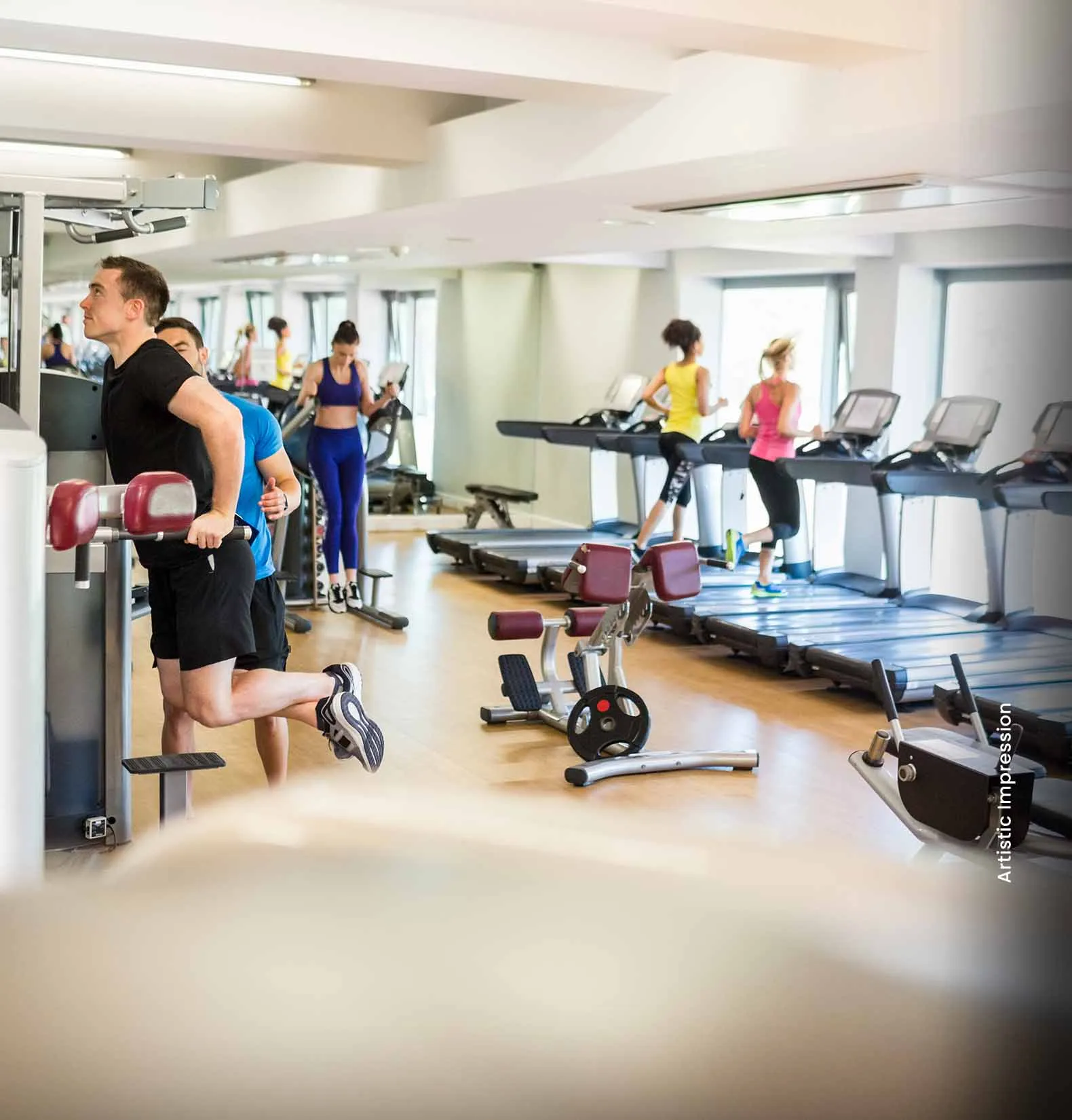 A fitness center with people exercising on machines and free weights, bright and spacious.