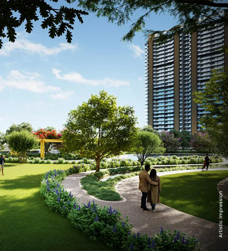 A couple walks along a winding path in a landscaped park with trees and flowers.