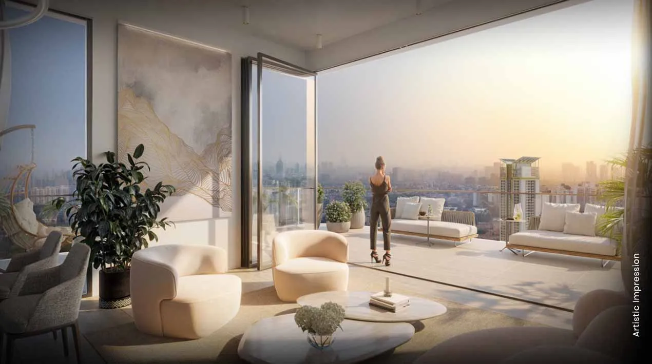 Stylish living room with large windows, plants, and a woman enjoying a sunset view.