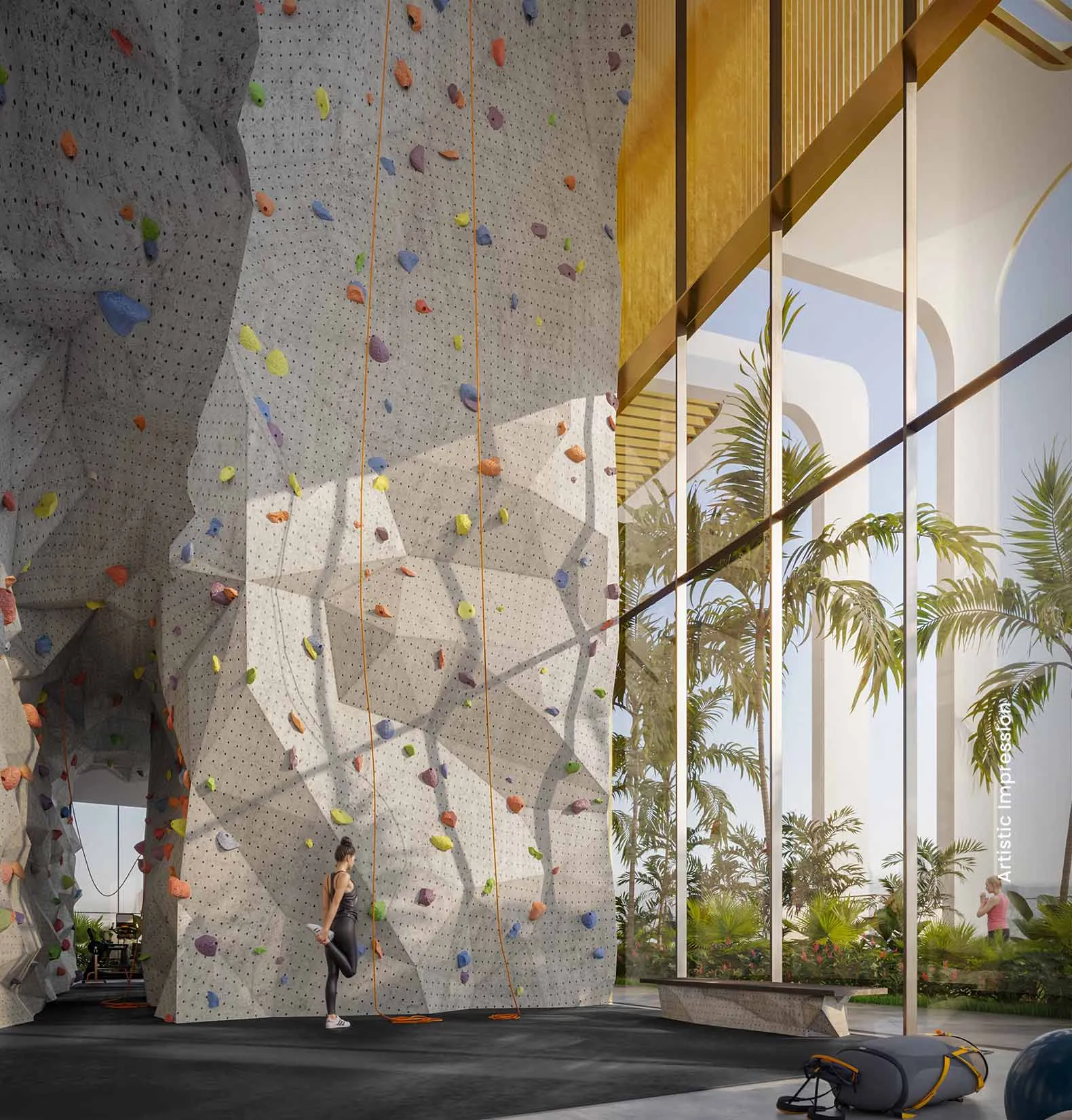 Indoor climbing wall with colorful holds, large windows, and tropical plants visible outside.