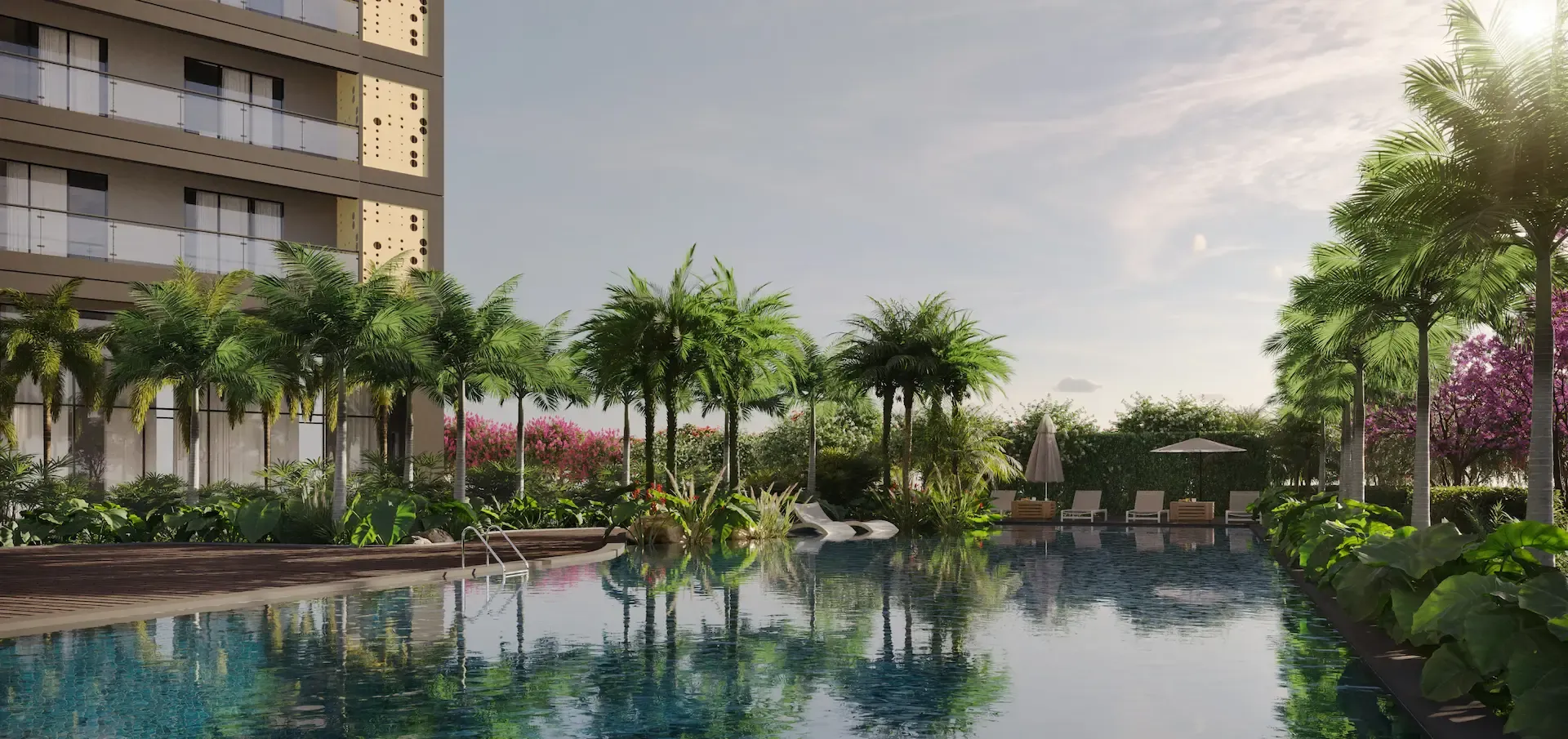 A serene swimming pool surrounded by lush greenery and palm trees, with lounge chairs nearby.