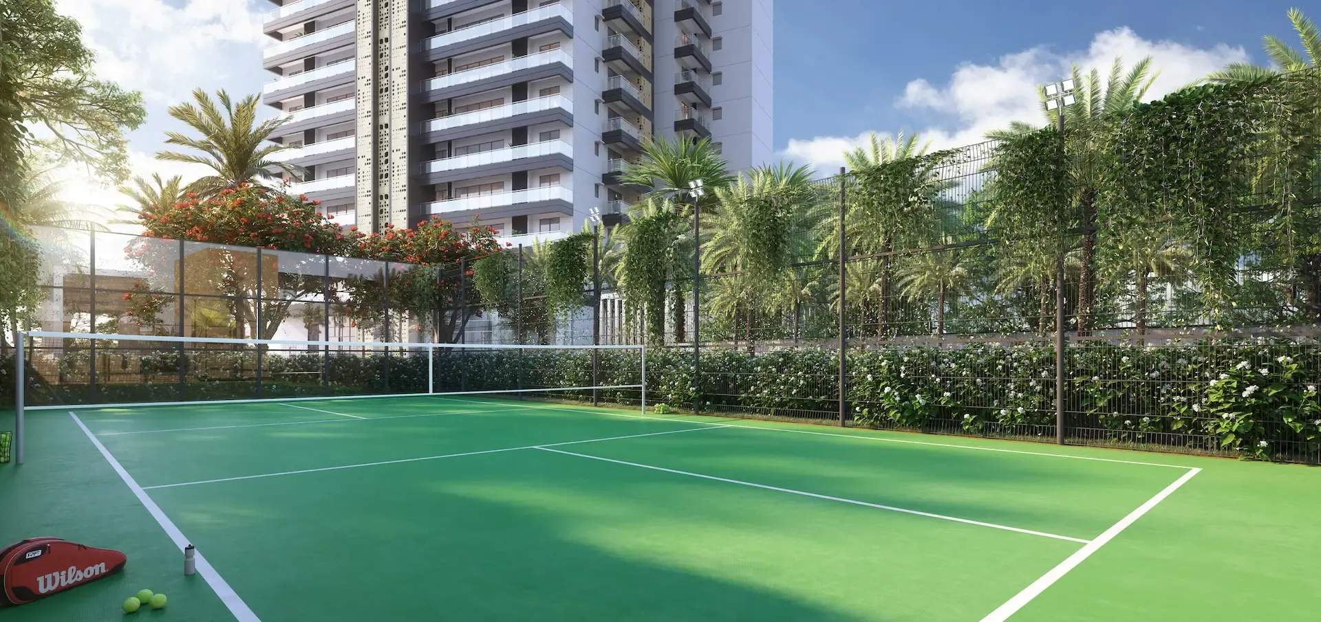 Green tennis court surrounded by palm trees and a residential building in the background.