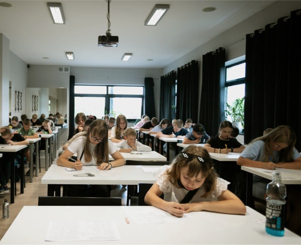 Uczniowie siedzą w sali