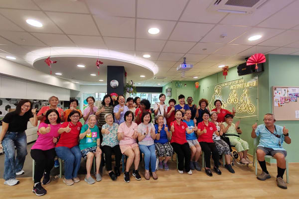 Seniors and SWA Laughter Yoga volunteers celebrating after the inaugural session at NTUC Health Active Ageing Centre Serangoon Central