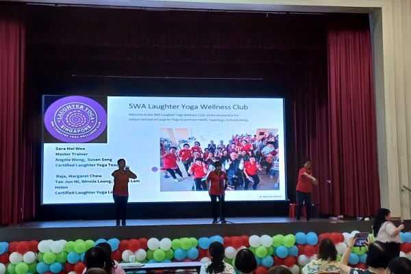 SWA Laughter Yoga Wellness Club presentation on stage at Bishan Community Club for International Women's Day 2026
