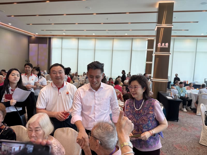 Mr Ng Shi Xuan giving ang bao to a senior at the celebration