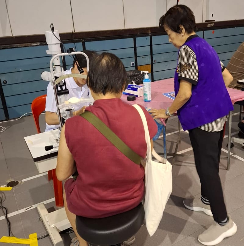 Doctor performing slit lamp examination on an elderly participant
