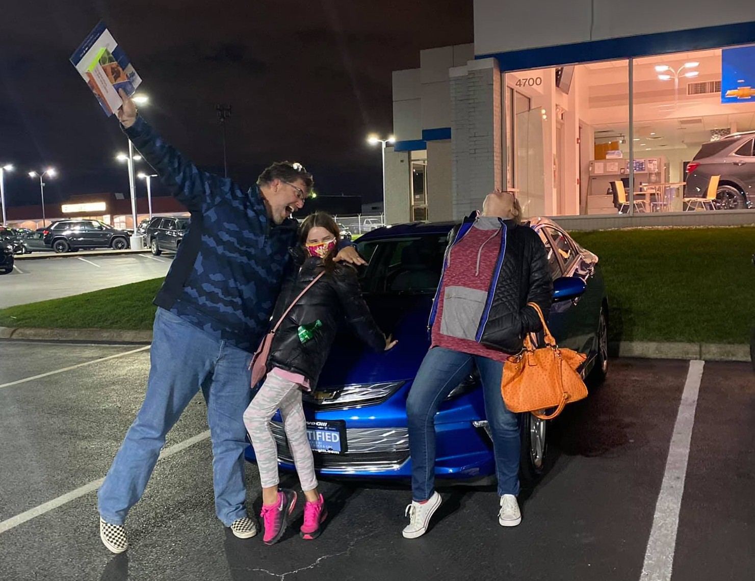 A happy family picking up their new vehicle with Scott