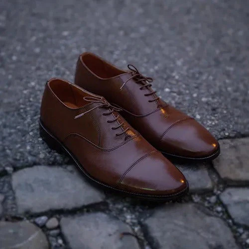 Brown leather brogue shoes on cobblestone