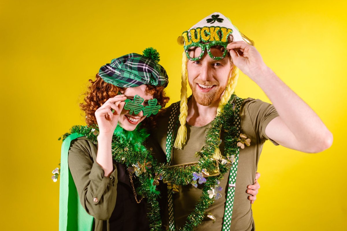 Joyful couple dressed in green celebrating St. Patrick's Day with festive accessories and bright smiles.