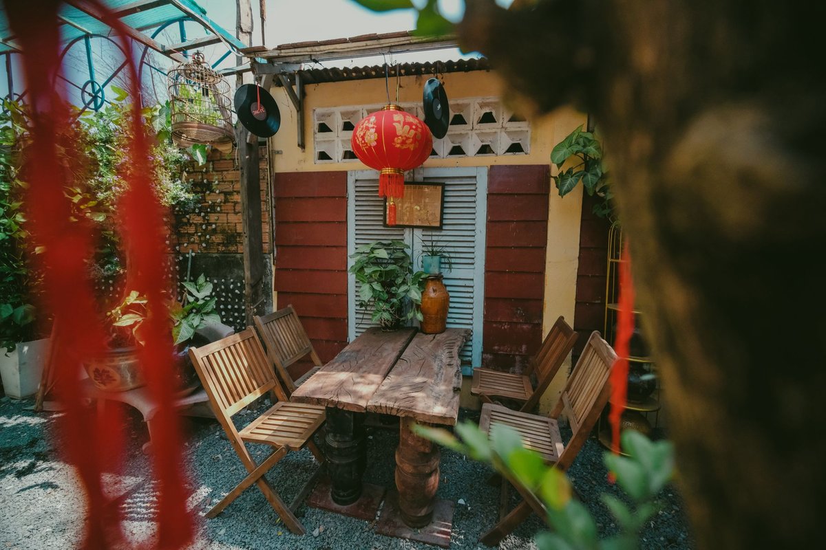 Beautiful outdoor patio scene with wooden chairs, table, and Asian decor.