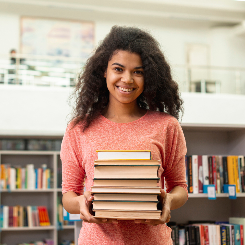 Young woman holding books in library