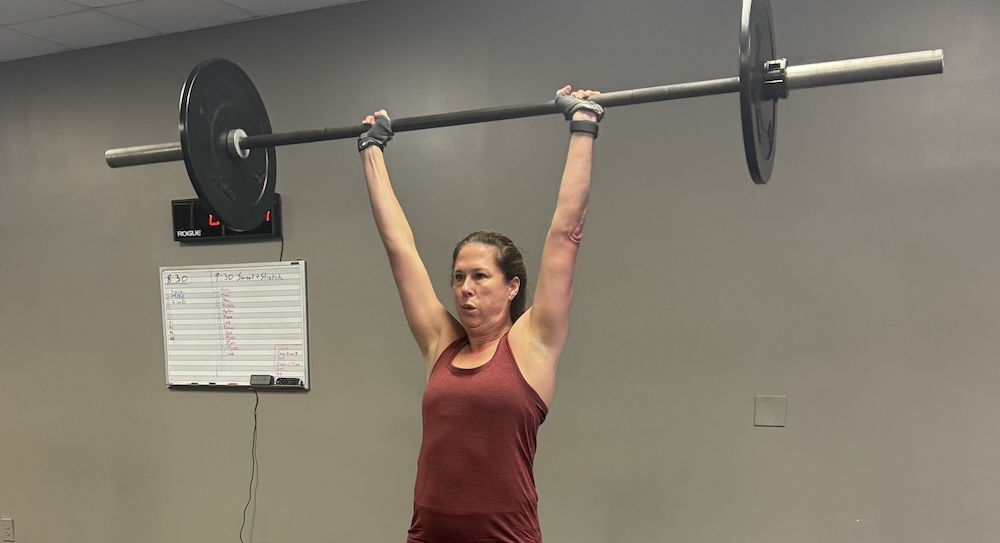 woman holding a barbell in a personal training session