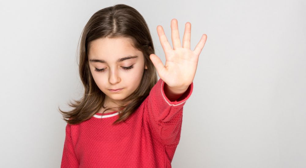 young girl holding up a hand to stop