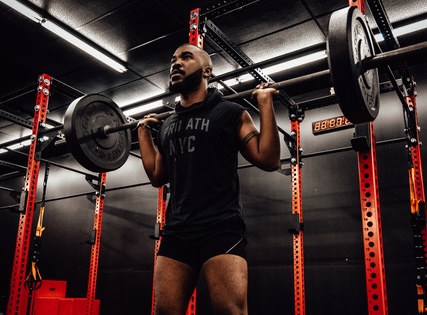 man holding a barbell on his shoulders