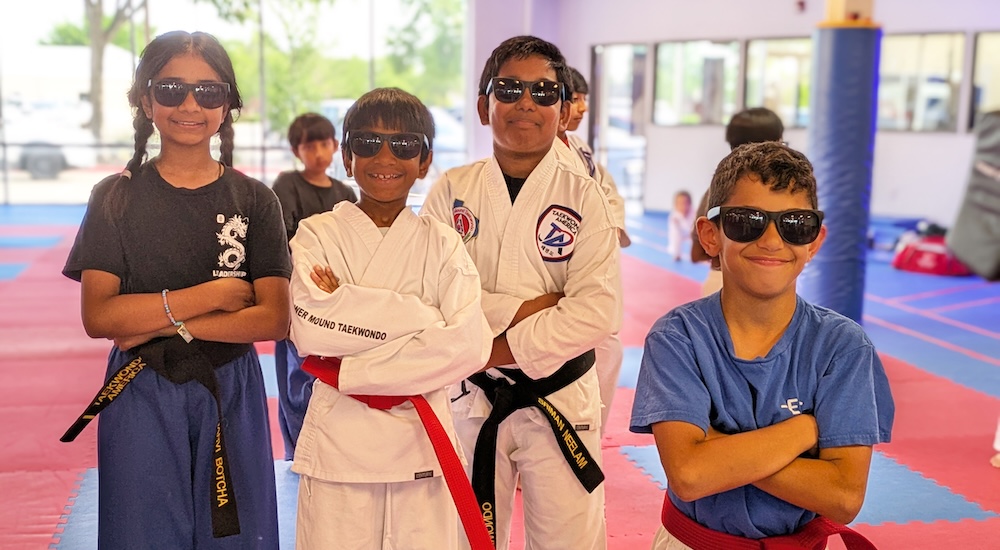 4 kids in taekwondo uniforms