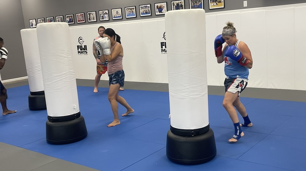 two women punching heavy bags
