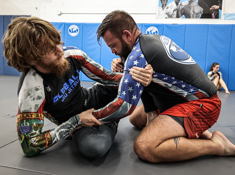 master deninho & a student practicing BJJ