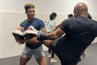 man kicking muay thai pads at POW! Gym Chicago