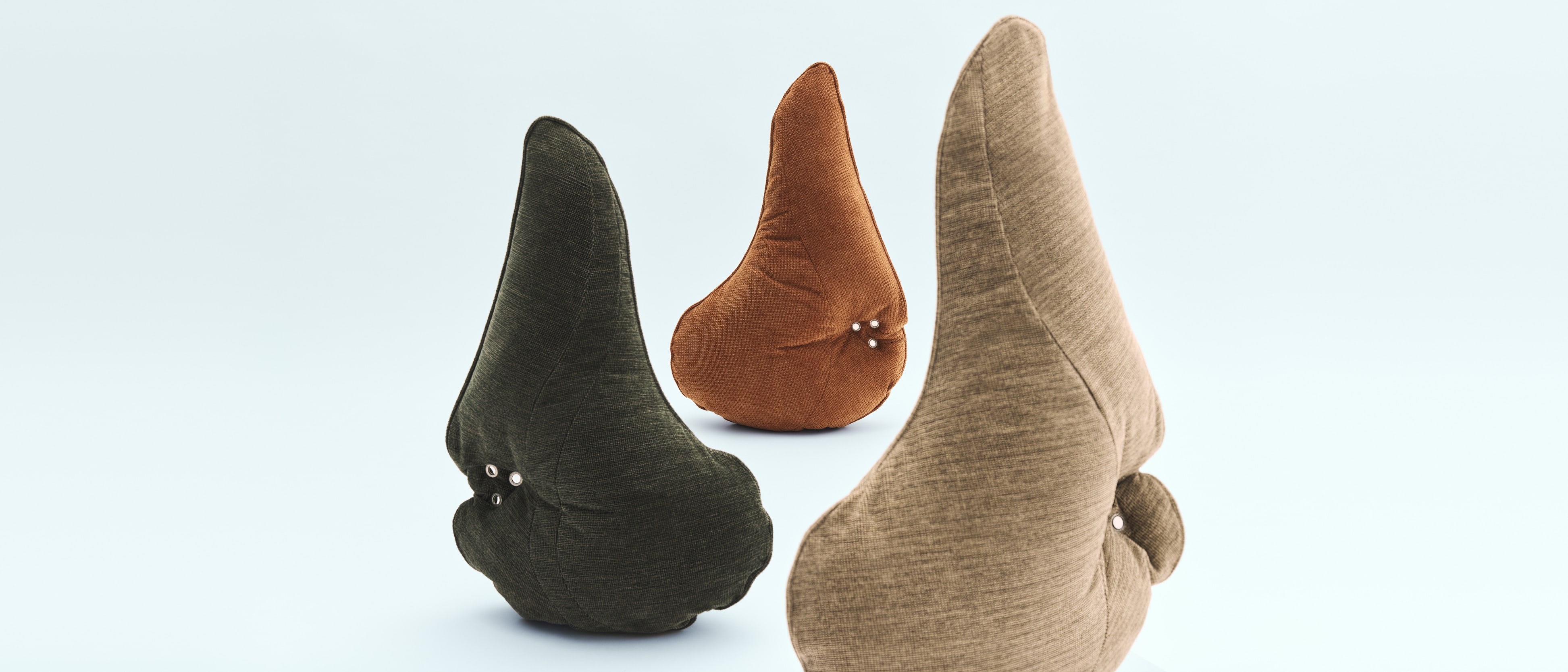 Three Flora Globe pillows in green, rust and sand