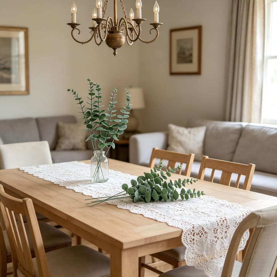 Green faux eucalyptus stems styled in a vase for dining table and home decor