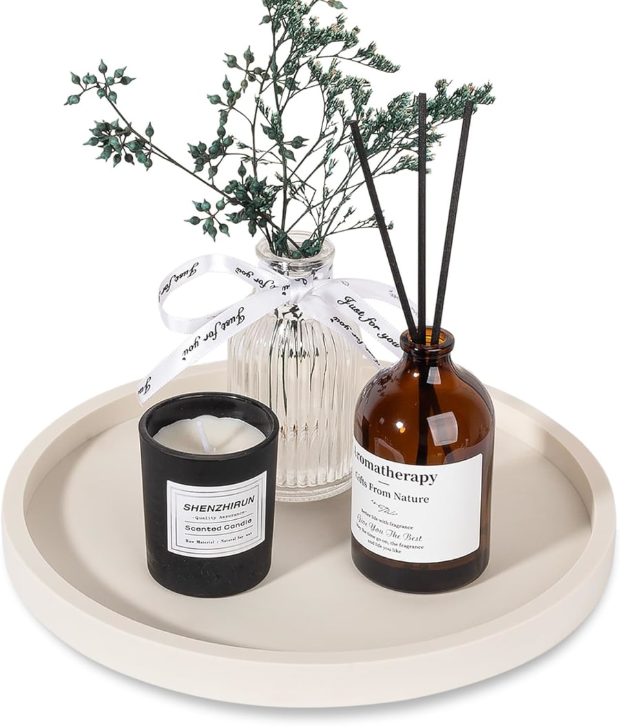 Round beige silicone organizer tray styled with a candle, diffuser, and decorative vase for a bathroom vanity or coffee table.