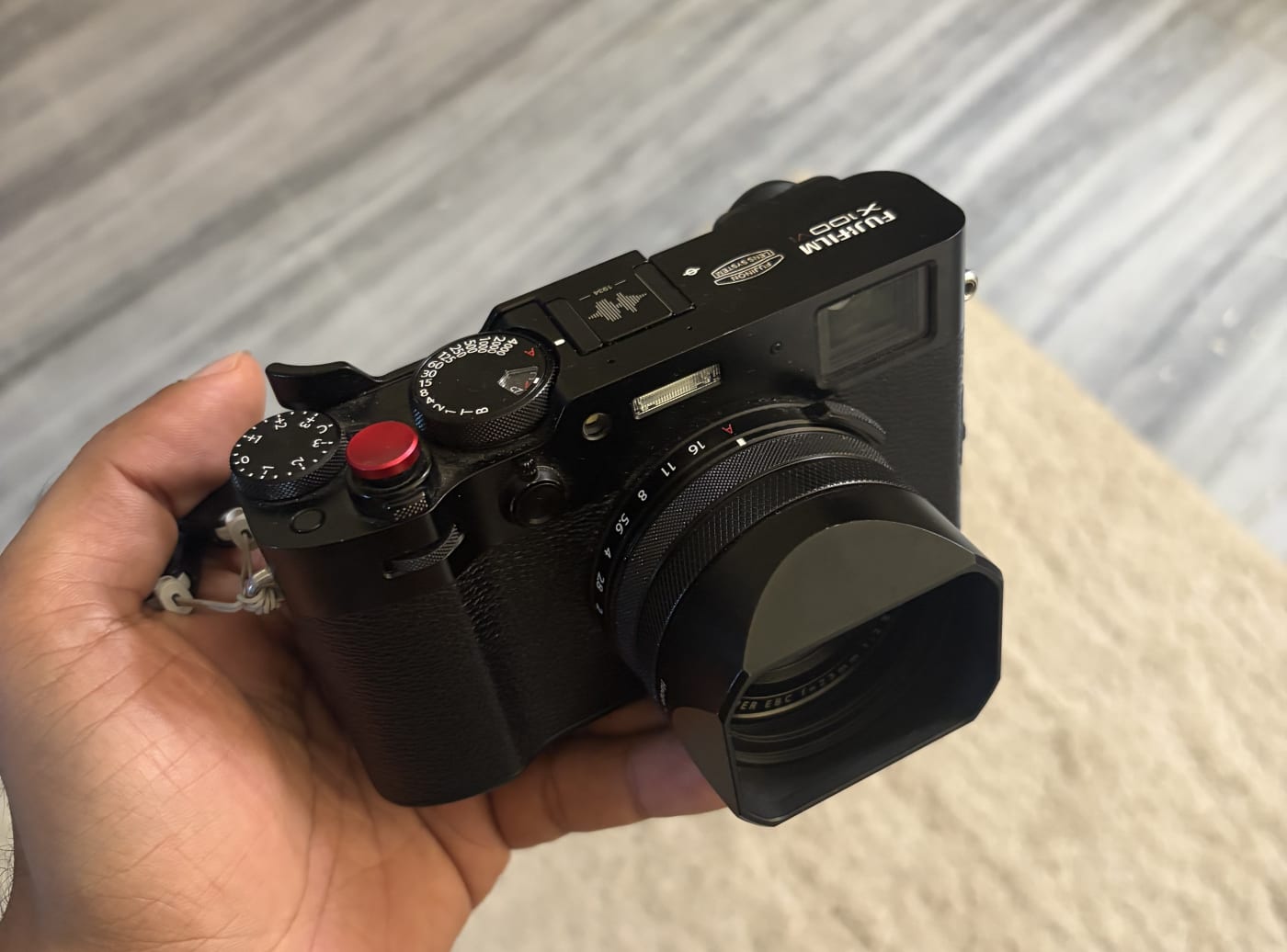 My black Fujifilm X100VI held in one hand, with the lens hood and soft shutter release fitted