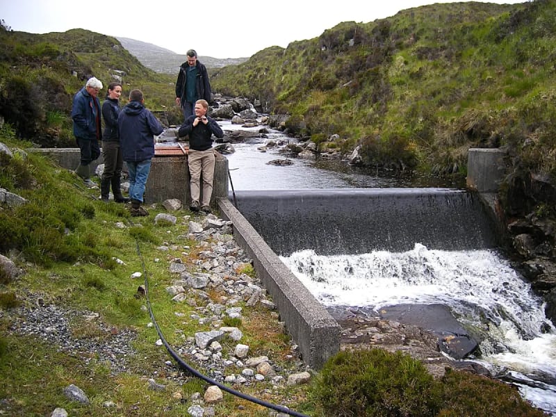 Community members and engineers at a hydro weir on Harris.