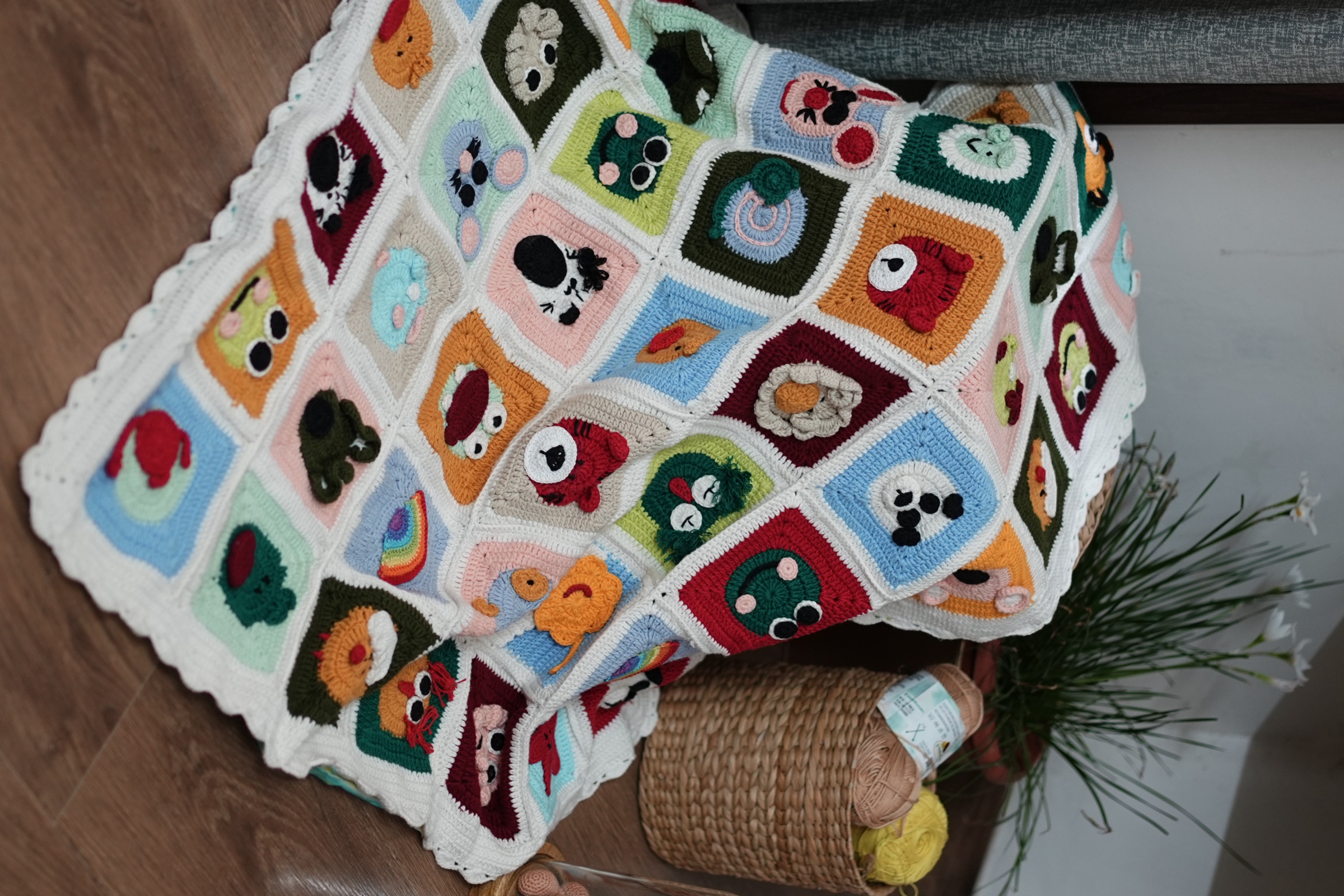Bed Time Buddies granny-square crochet blanket with colorful animal faces and a cream scalloped border