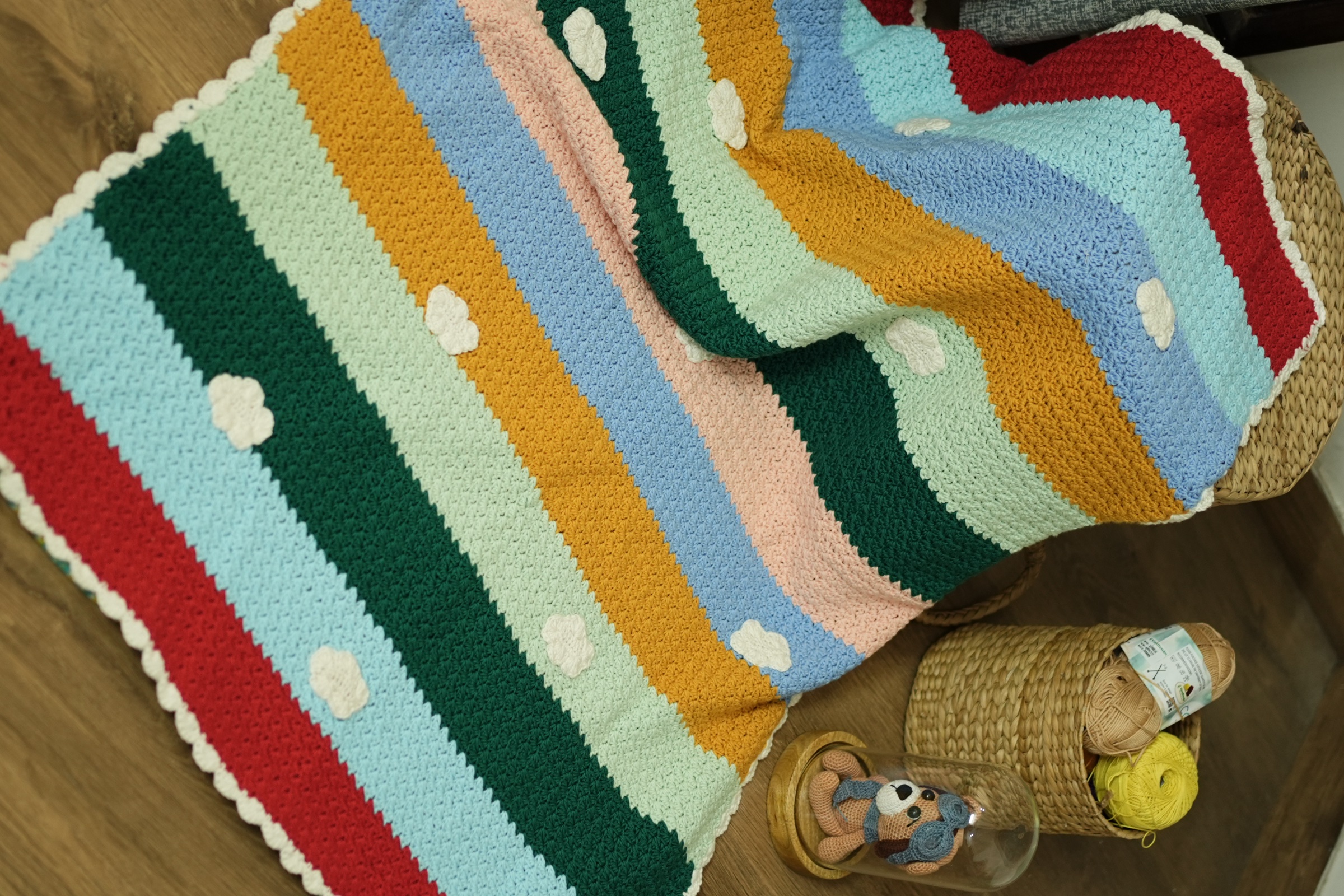 Rainbow Nest striped crochet blanket with cream cloud appliqués