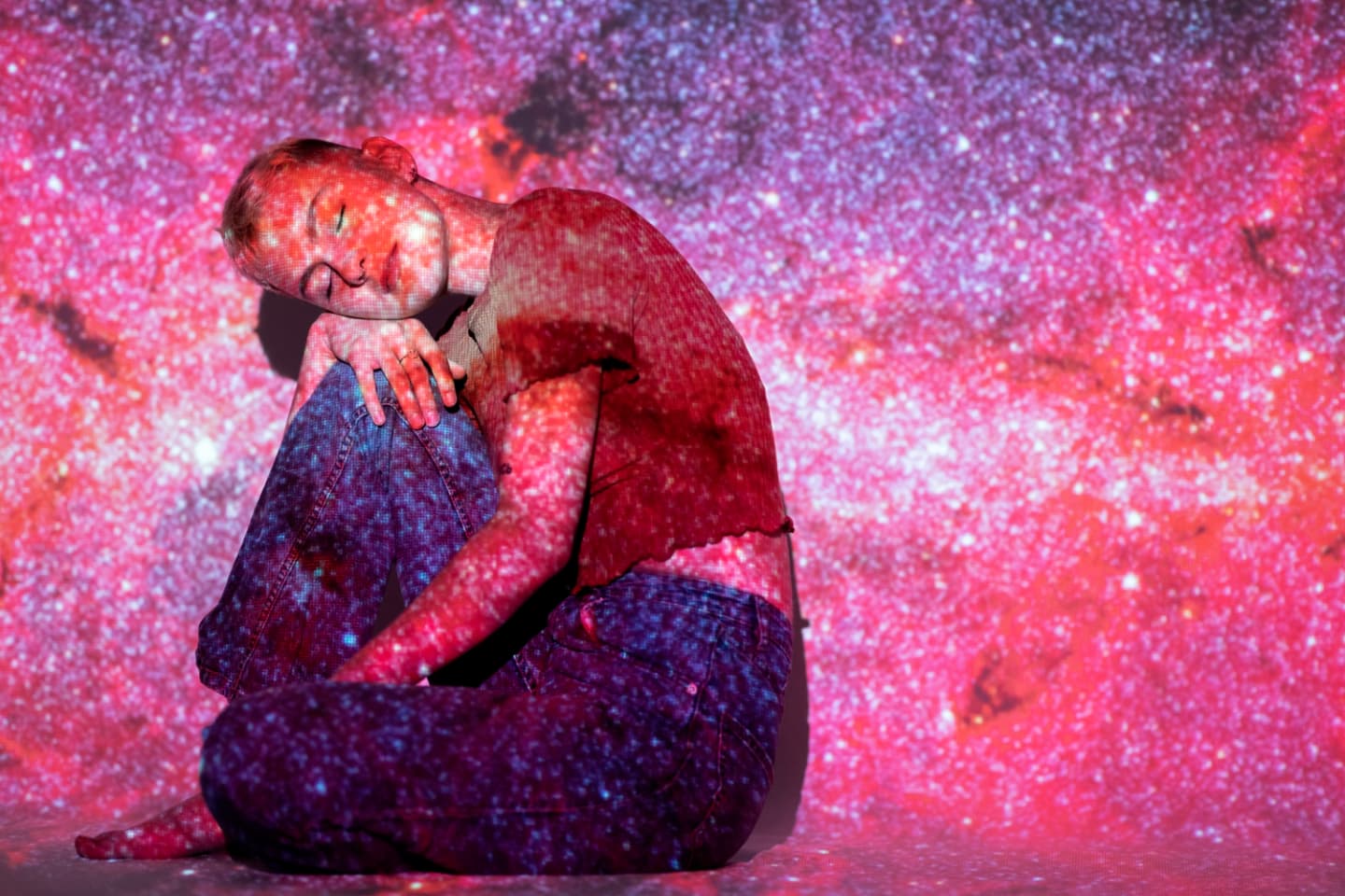 Portrait of a young woman posing with a universe projection texture