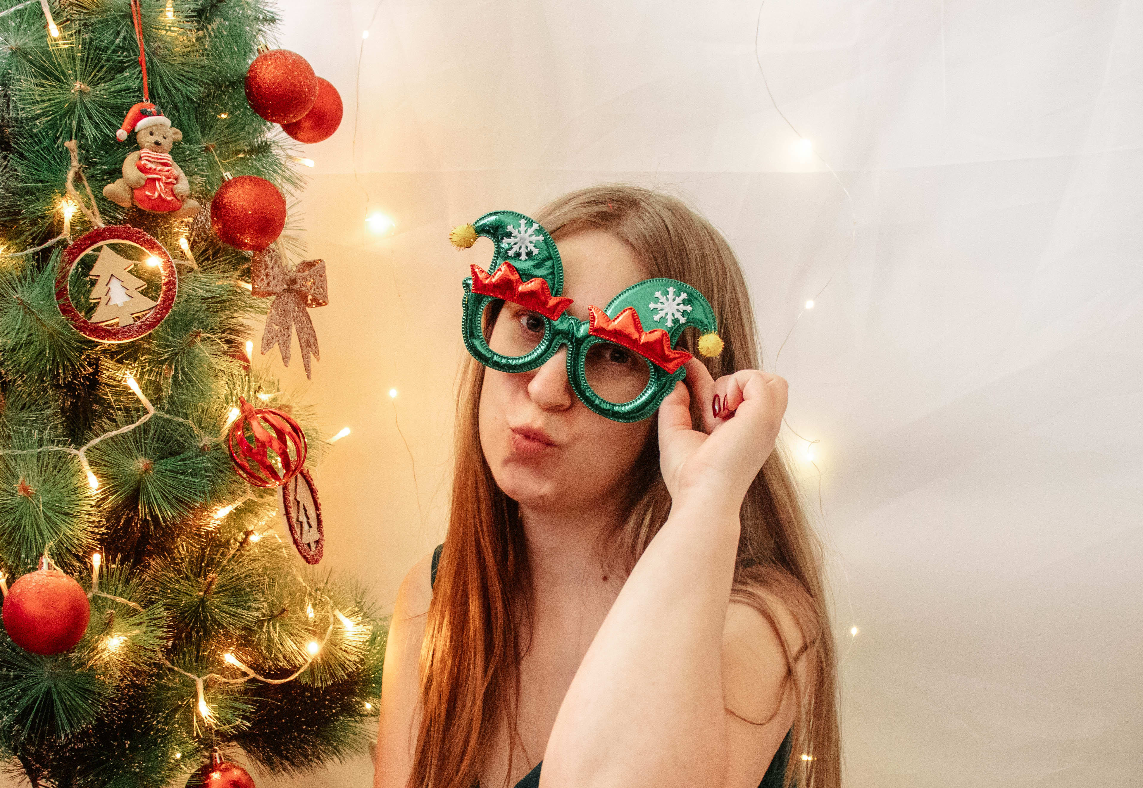 Dziewczyna w stroju swiatecznym przy choince w studio fotograficznym Zaczarowany Kadr.