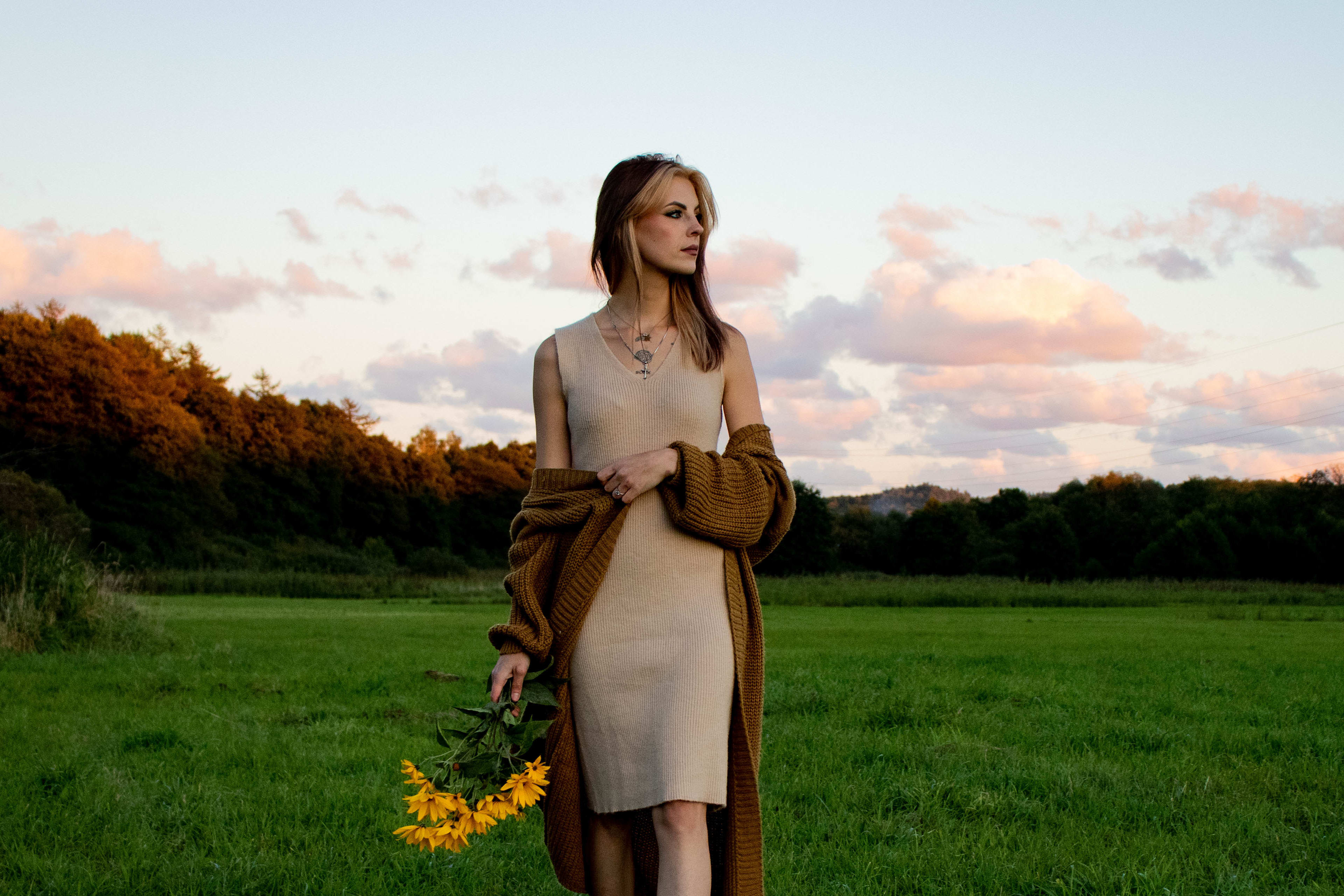 kobieta trzymajaca kwiaty na spacerze