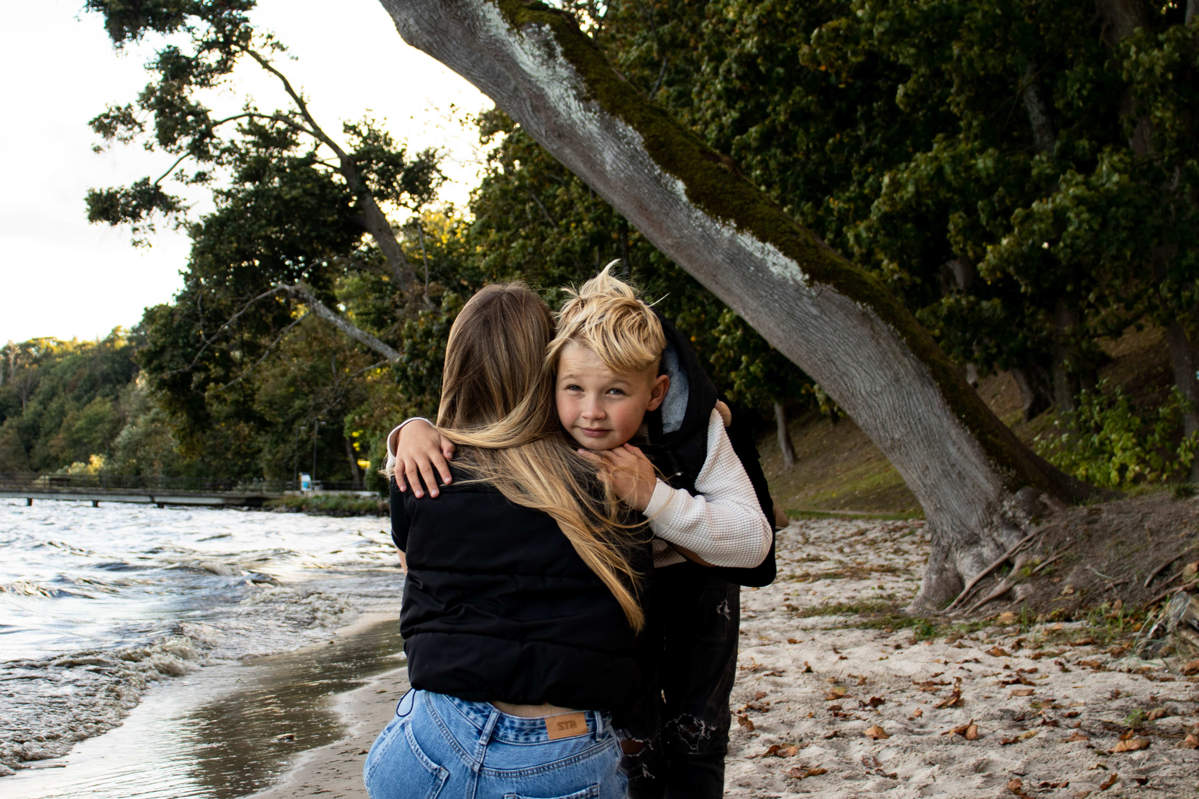 Mama z dzieckiem przytula sie na plazy, sesja rodzinna.