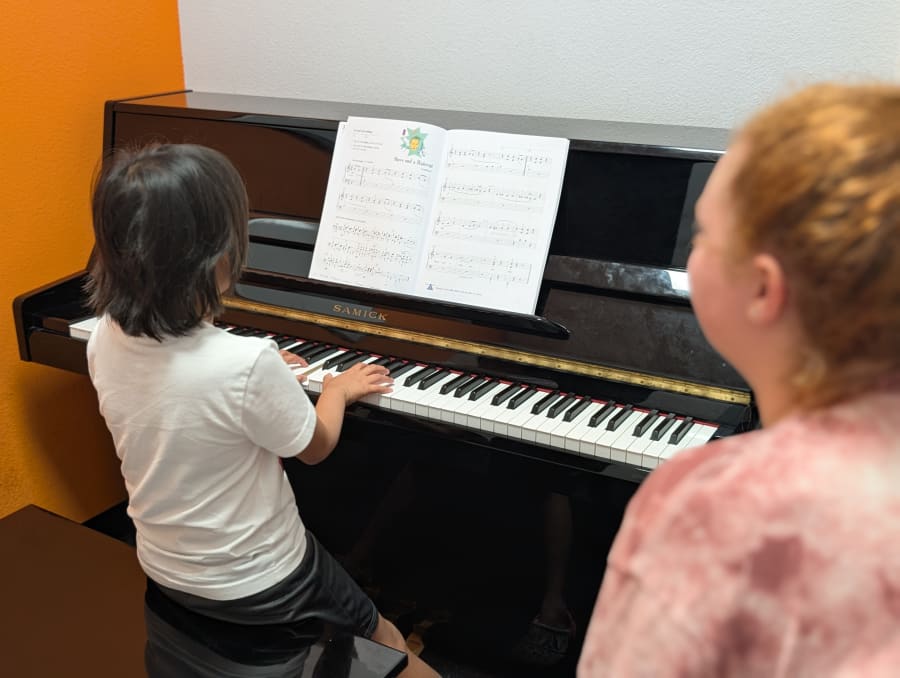 A piano student learning with a teacher