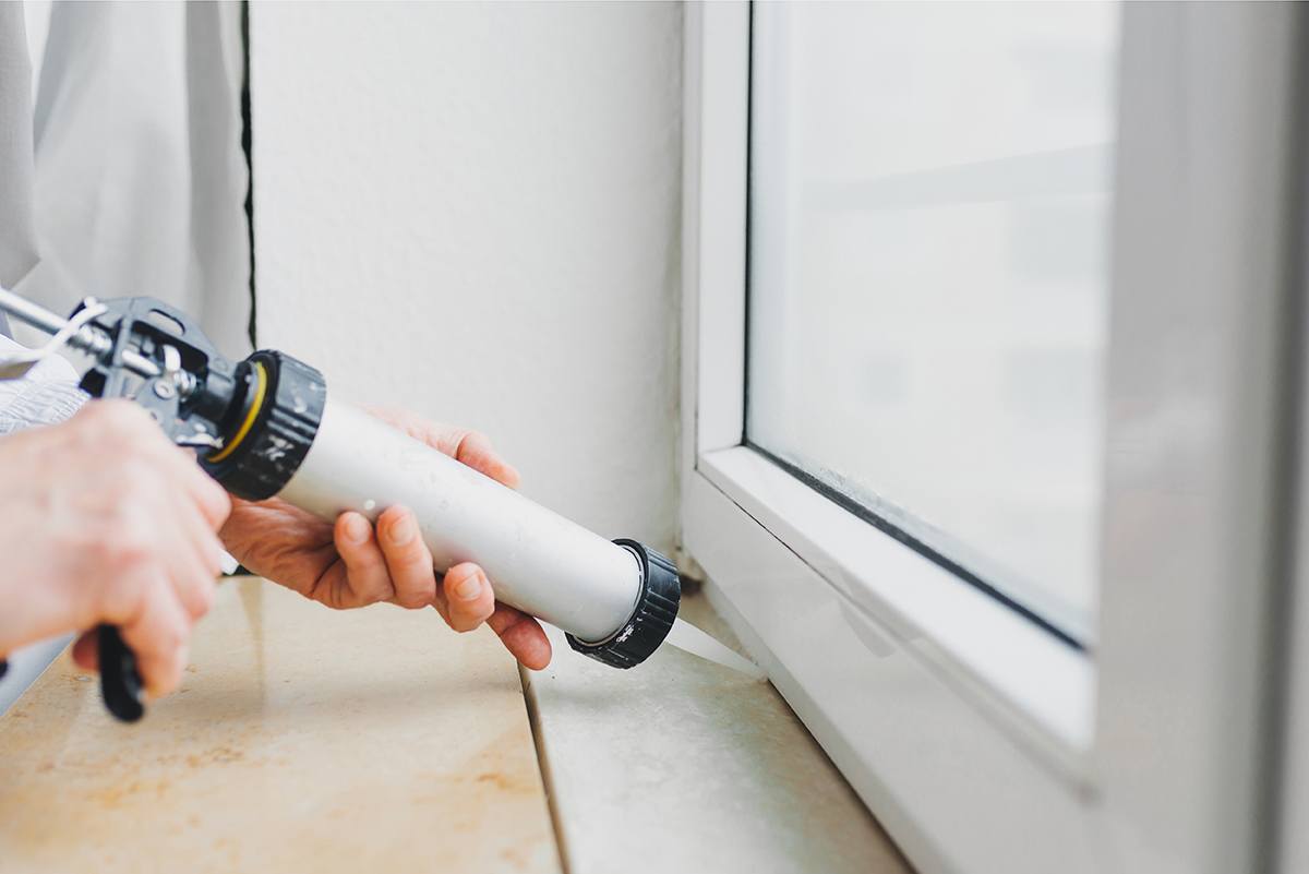 Man Caulking Window