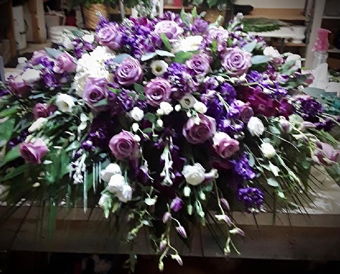 Shades of lavender and purple flowers in a funeral spray  Church flower  arrangements, Funeral flower arrangements, Funeral flowers