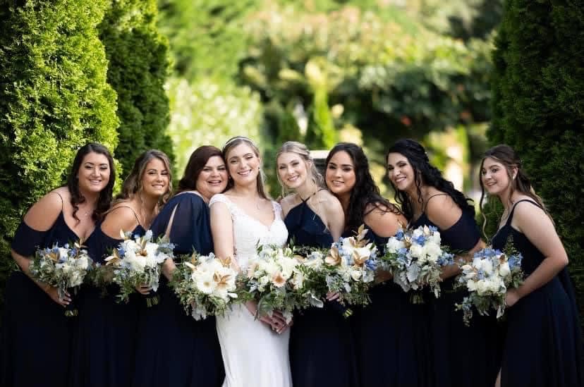 bridesmaids taking pictures with there wedding flowers