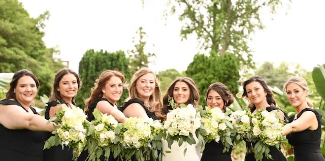 bridesmaids taking pictures with there wedding flowers